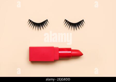 False eyelashes and red lipstick on a beige background.Beauty and makeup concept Stock Photo