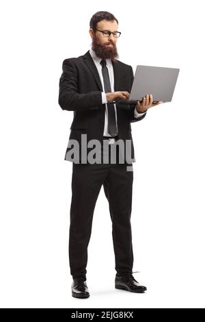 Full length portrait of a bearded man in a suit standing and using a laptop computer isolated on white background Stock Photo