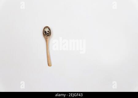 Quail egg in a wooden spoon, protect the egg, on beige clear color background. Farmers market eggs, cooking eggs Stock Photo