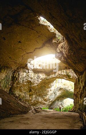 tourist cave .High arches of a huge stone cave with round holes at the ...
