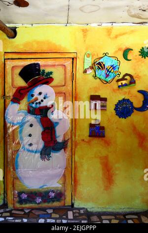 Snowman Christmas decoration and brightly painted ceramics on wall of house, Boquete, Chiriqui, Panama Stock Photo