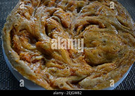 Delicious sweet homely pie. Charpell made at home. Biscuit dough with banana pieces of fresh apples. Stock Photo
