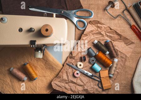 Thread, scissors and sewing supplies on a vintage background. Top view. Sewing concept. Stock Photo