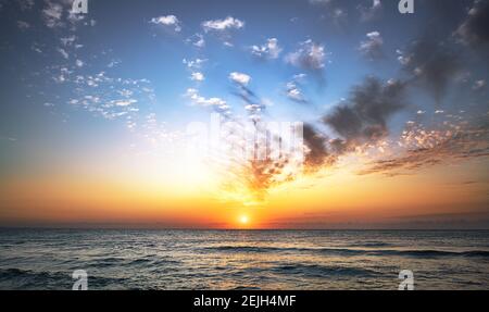 Beautiful sunset sky above clouds over the ocean. Stock Photo