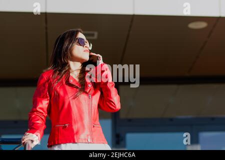 Hispanic woman talking on the phone outdoors Stock Photo