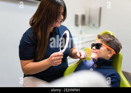 Dentist shows mirror to boy Stock Photo