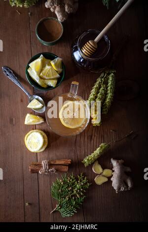 Dried mountain tea, turmeric, cinnamon sticks, lemon slices and jar of honey on wooden background.  Sideritis Scardica. Stock Photo