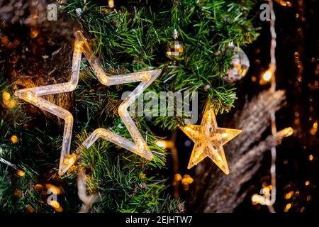 Garland in shape of Led Christmas star in decor, blurred bokeh background. Stock Photo