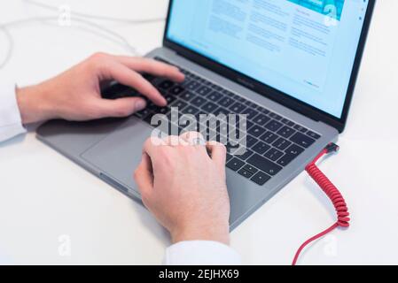 A person works and types on a lap top computer Stock Photo