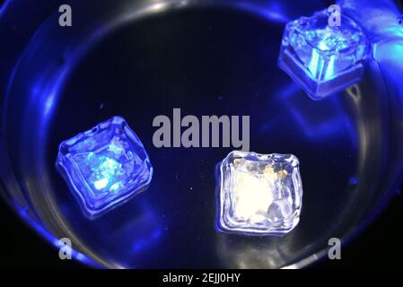 Led blue, white ice floes are floating in a stainless steel dipper with an interesting metal reflection. Stock Photo