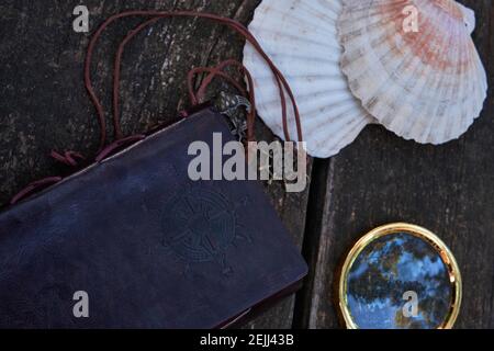 on the wooden table is a leather-bound notebook Stock Photo