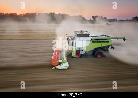 Panning Motion Blur Aerial Image. Harvester working at field moving side along camera. Direct Aerial view using motion emphasizing method. Agricultura Stock Photo