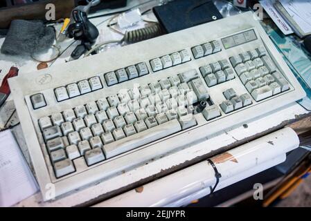 A dirty and well used computer keyboard in a cycle workshop Stock Photo