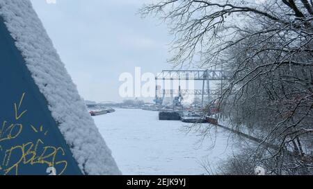 Brunswick, Germany. 12th Feb, 2021. A view across the frozen Mittelland Canal to the port of Braunschweig. Numerous ships have been moored in the inland port of the former Hanseatic city for several days because the Mittelland Canal has frozen over. All icebreakers have been called off to keep the Weser free of ice. Credit: Stefan Jaitner/dpa/Alamy Live News Stock Photo