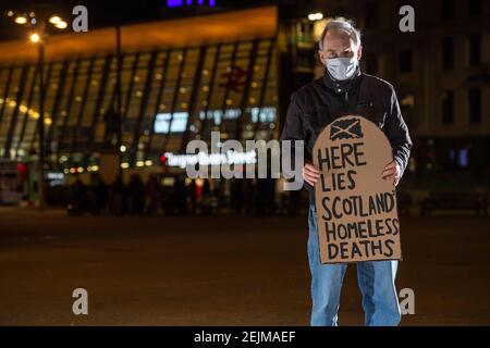 Glasgow, Scotland, UK. 22nd Feb, 2021. Pictured: Sean Clerkin - Scottish Tenants Organisation, holding a gravestone shaped placard which reads, “HERE LIES SCOTLANDS HOMELESS DEATHS”. Today 23rd Feb 21, the Scottish Government has released the homeless deaths figures 3 days early which are up by an increase of 11% from last year. The link https://www.nrscotland.gov.uk/news/2021/homeless-deaths-2019 shows the article today. Credit: Colin Fisher/Alamy Live News Stock Photo