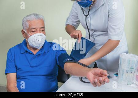 shows how to measure blood pressure in an older man Stock Photo