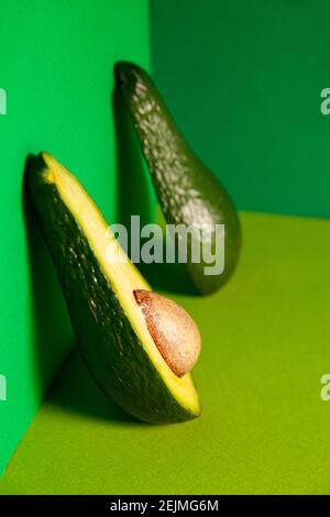 4 halved avocados sit on a cute cow-shaped wooden cutting board. A bowl of  fresh cucumbers sits in background. Dinner at home Stock Photo - Alamy