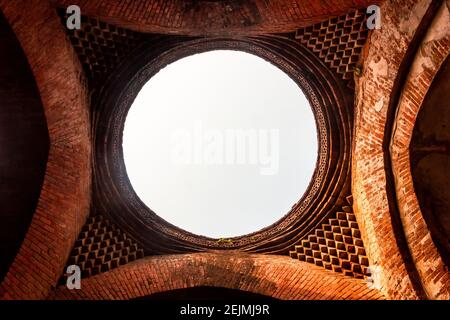 An ornate roof of a ceiling with a circular opening with a view of the sky in the ruins of the ancient Adina Masjid mosque in the village of Padua nea Stock Photo