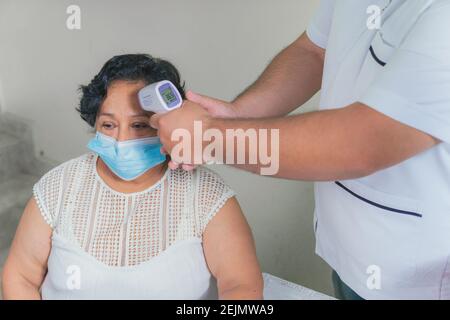 view of an older woman checking the temperature with a digital thermometer Stock Photo