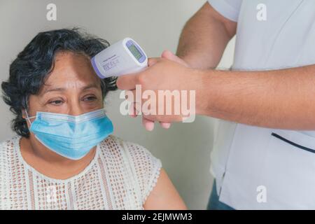 view of an older woman checking the temperature with a digital thermometer Stock Photo