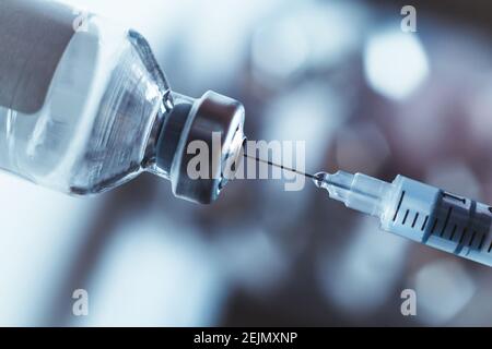 Syringe draws vaccine from ampoule. Coronavirus and flu cure. Close-up view. Stock Photo