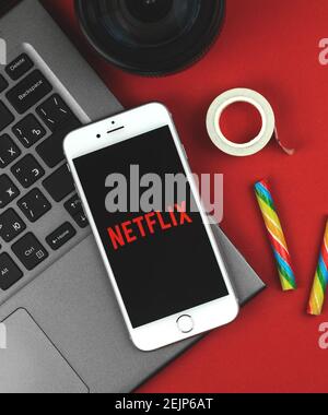 Kharkov, Ukraine - February 22, 2021: Netflix logo on smartphone Apple, mobile application of streaming service, flat lay creative composition, red ba Stock Photo