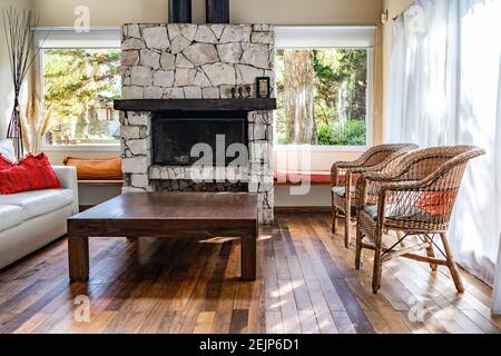 Empty wood coffee table in a living room.  Stone fireplace. Stock Photo