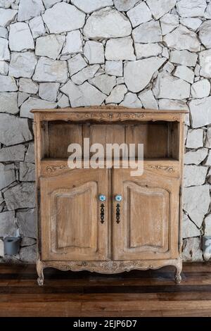 Wooden old small empty cabinet over a stone wall Stock Photo