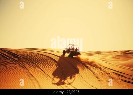 Buggy quad bike with smoke rides in Dubai desert dunes safari Stock Photo