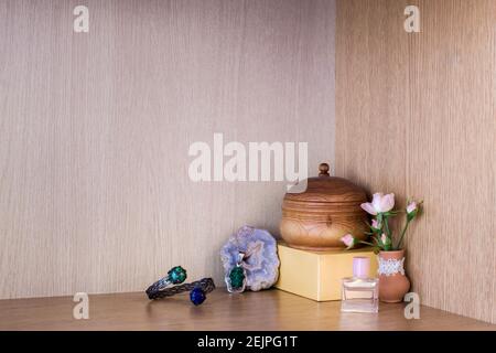 Perfume with jewelry by flower vase in the corner on a wooden shelf Stock Photo