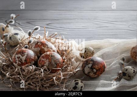 Easter composition - several marble eggs painted with natural dyes in a paper nest on the table, copy space. Stock Photo