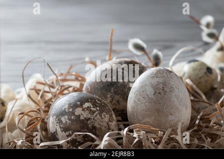 Easter composition - several marble eggs painted with natural dyes in a paper nest on the table, copy space. Stock Photo