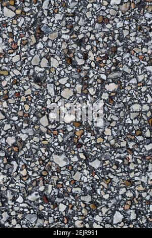 Asphalt background paved road cobblestone closeup abstract directly above in vertical format. Patterns and textures flat lay. Stock Photo