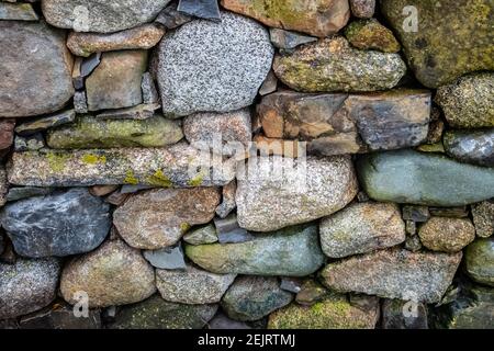A close-up of an old hand-stacked Rock Seawall in afternoon summer light. Stock Photo