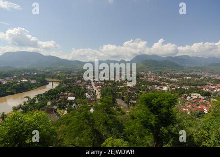 Beautiful Panorama view from Phousi Mountain over the UNESCO heritage town of Luang Prabang, Laos, on a clear sunny day, towards Nam Khan River. . Stock Photo