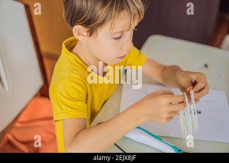 Kid using 3d printing drawing pen. Creative, leisure, technology education concept Stock Photo