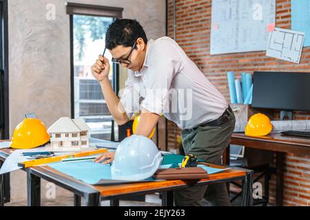 Engineer woman read drawing blue print on table workplace at room site construction. Engineer architect plan concept. Stock Photo