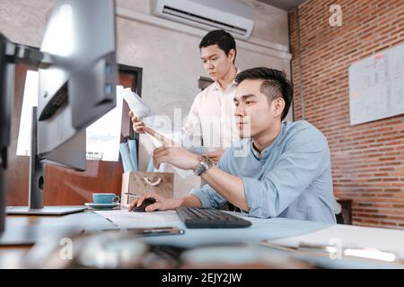 engineers reading building and  drawing outlay construction plan as guide for builders with details on computer. Engineer design and writing blueprint Stock Photo