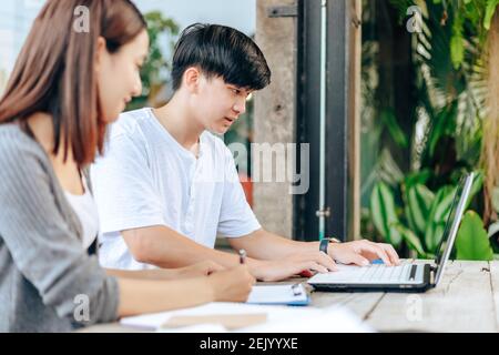 High school or college students  group catching up workbook and learning tutoring on desk and reading, doing homework, lesson practice preparing exam. Stock Photo