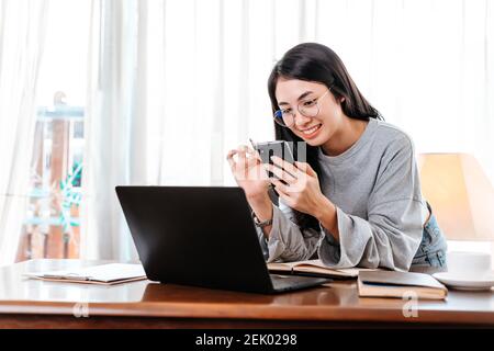woman using mobile phone while working at home. Businesswoman working concept. Stock Photo