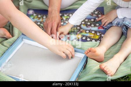 Selective focus of family playing board game in the park. Childhood Stock Photo