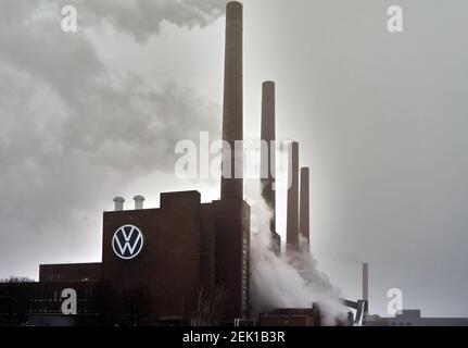 VW combined heat and power plant with smoking and steaming chimneys and the Volkswagen emblem on the brick wall in Wolfsburg, Germany, February 8, 202 Stock Photo