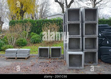 Reinforced concrete square box culverts & culvert lids on a construction site in NE Italy. Rolls of black corrugated flexible drainpipes on the right Stock Photo