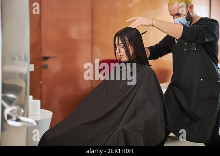Young relaxed attractive customer getting her haircut Stock Photo