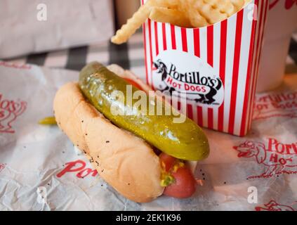A classic Chicago-style hot dog and crinkle French fries from Portillo's Hot Dogs in Chicago, Illinois. Stock Photo