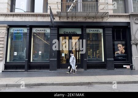 A woman walks past Chanel store which remains close due tothe