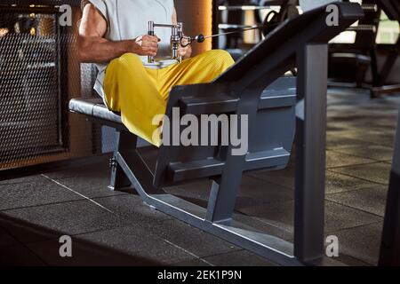 Fit man exercising on a sitting rowing machine at gym Stock Photo