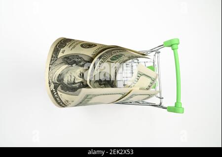 one hundred dollar bills in a shopping cart, top view, on an isolated white background . High quality photo Stock Photo
