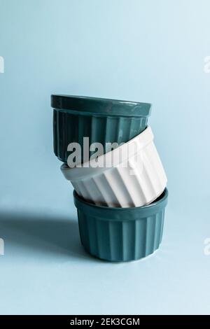 Ceramic Round Ramekins on a blue background. Vertical photo Stock Photo
