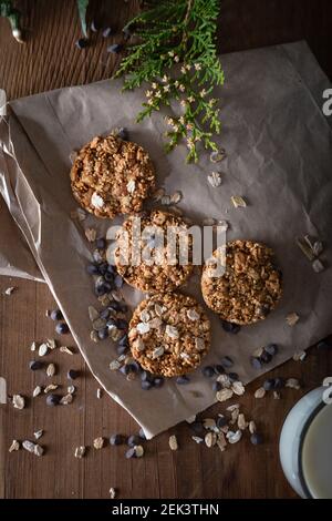 Oatmeal chocolate chip cookie with glass of milk. Healthy cookies on natural wooden background. Stock Photo